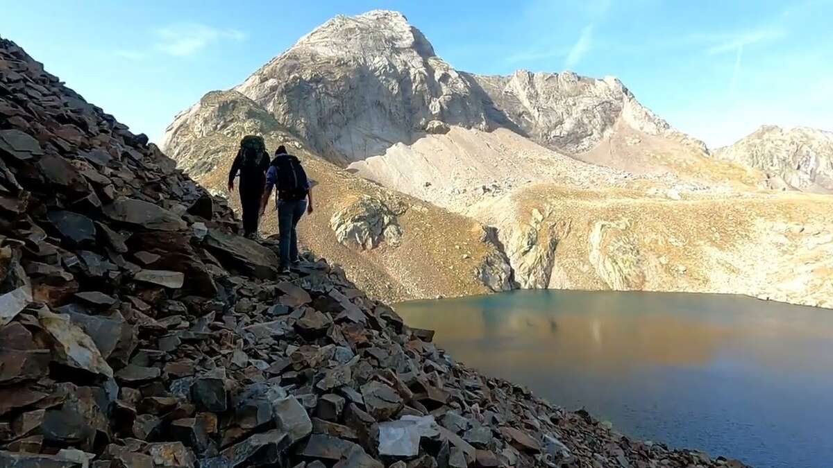 Groupe de randonneurs accompagnés marchant sur un sentier isolé en pleine montagne